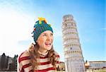 Young, itching from energy and searching for excitement.I'm going to Christmas trip to Italy. It is a no-brainer.Happy woman in Christmas tree hat looking on something in front of Leaning Tour of Pisa