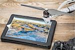 drone aerial photography concept - reviewing aerial picture of Colorado foothills near Fort Collins on a digital tablet with a drone rotor and radio control transmitter, winter scenery