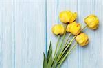 Yellow tulips over wooden table background with copy space