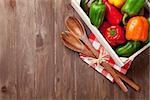 Fresh colorful bell pepper box on wooden table. Top view with copy space