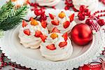 Pavlova meringue cake decorated with fresh strawberry and cape gooseberry on festive background