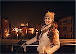 Tune in for charming winter time in Venice, Italy. Smiling young woman standing on a bridge overlooking Grand canal