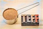 gluten free teff grain in a metal measuring scoop with a text in vintage letterpress wood type blocks