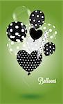 Black and white balls round and heart-shaped with a polka dot pattern on green background