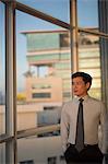 Singapore, Businessman standing at window in office