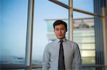 Singapore, Indoor portrait of businessman standing in front of window