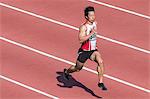 Japanese male sprinter running on track