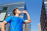 Young Caucasian man drinking water in metropolitan area