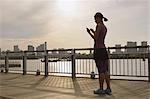 Young Japanese with smartphone during her run downtown Tokyo