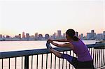 Young Japanese woman stretching before her run downtown Tokyo