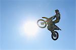 Motocross biker jumping over dirt track