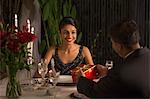 Singapore, Man giving gift box to woman at romantic dinner