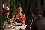 Singapore, Woman holding gift box at romantic dinner