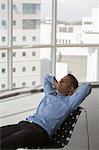 Singapore, Businessman reclining in chair in empty office