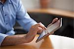 Singapore, Businessman using digital tablet at table