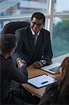 Singapore, Woman looking at two businessmen shaking hands