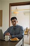 India, Businessman at breakfast table sitting with hands folded