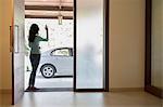 India, Woman waving goodbye at front door