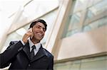 India, Smiling businessman outside office building talking on mobile phone
