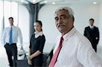 India, Senior business man standing in front of colleagues
