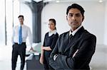 India, Business man standing with arms crossed in front of colleagues