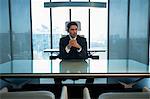 India, Businessman sitting at desk with hands clasped in office