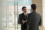 India, Two businessmen talking in office lobby