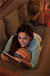 Singapore, Woman relaxing with digital tablet at night