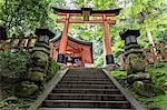 Moss covered Shinto shrine surrounded by thick forest in summer, Fushimi Inari Taisha, Mount Inari, Kyoto, Japan, Asia