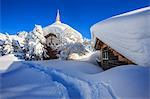 The small church and the house submerged by snow after a heavy snowfall in Maloja, Engadine, Graubunden (Grisons) Canton, Switzerland, Europe