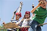 Children playing pirate game in adventure playground, Bavaria, Germany