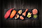 Sushi on black stone slate plate, black wooden background