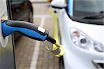 Electric car being charged at the station, close up of the power supply plugged