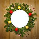 Christmas Decoration Round Frame with firtree, candies and baubles with stars on rustic wood, copy space for text