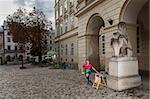 Woman punching at control point, taking part in orienteering city race competitions in old european city