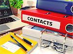 Contacts - Red Office Folder on Background of Working Table with Stationery, Laptop and Reports. Business Concept on Blurred Background. Toned Image.