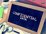 Confidential Data - Chalkboard with Hand Drawn Text, Stack of Office Folders, Stationery, Reports on Blurred Background. Toned Image.