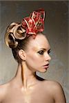 pretty girl with perfect skin with freckles posing turned on profile with creative glossy christmas make-up and red ribbon in elegant hair-style