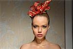 beauty portrait of pretty woman with freckles, creative christmas glossy golden make-up and red ribbon in hair-style