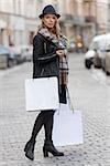 beautiful elegant young woman walking on the street , with hat and scarf ready for shopping sales