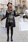 pretty and sweet blond woman , she is looking up and enjoy all the staff she was buying , she wear hat.