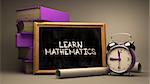 Learn Mathematics - Chalkboard with Hand Drawn Text, Stack of Books, Alarm Clock and Rolls of Paper on Blurred Background. Toned Image.
