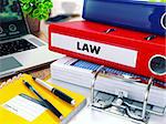 Law - Red Ring Binder on Office Desktop with Office Supplies and Modern Laptop. Business Concept on Blurred Background. Toned Illustration.