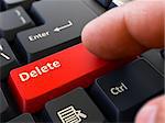 Delete - Written on Red Keyboard Key. Male Hand Presses Button on Black PC Keyboard. Closeup View. Blurred Background.