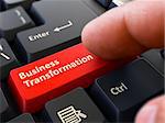 Business Transformation - Written on Red Keyboard Key. Male Hand Presses Button on Black PC Keyboard. Closeup View. Blurred Background.