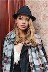 beautiful woman near an old fashion home door , with hat scarf and a sexy dress, natural look .