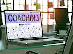 Coaching - Closeup Landing Page in Doodle design style on Laptop Screen. On background of Comfortable Working Place in Modern Office. Toned, Blurred Image.