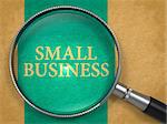 Small Business Concept through Magnifier on Old Paper with Blue Vertical Line Background.