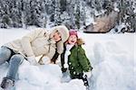 Winter outdoors can be fairytale-maker for children or even adults. Portrait of smiling mother and child playing with the snow outdoors