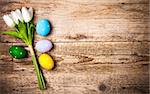 Easter eggs with bunch tulips copyspace on wooden board